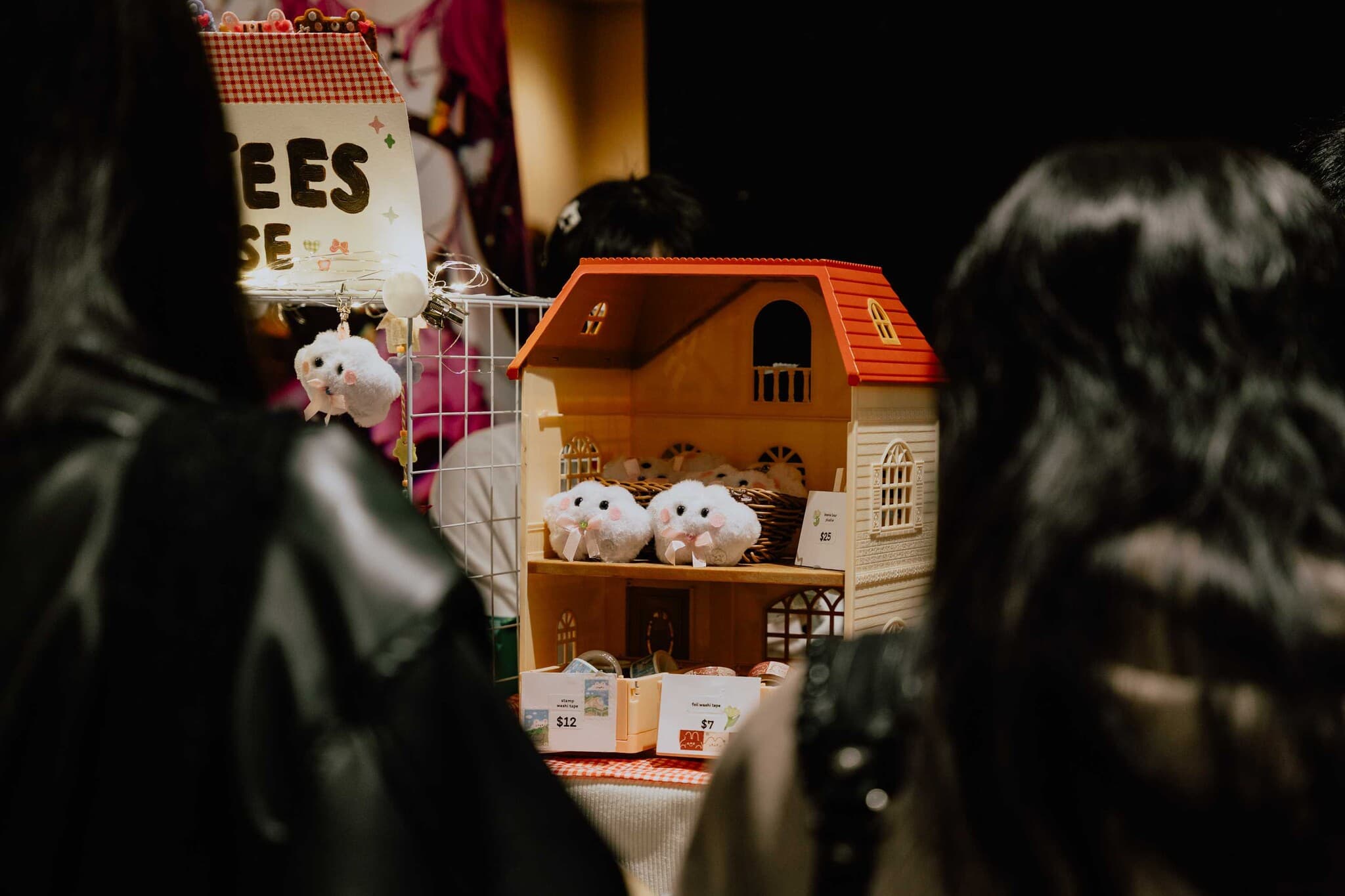 Plush hamsters peeking out of a tiny wooden house