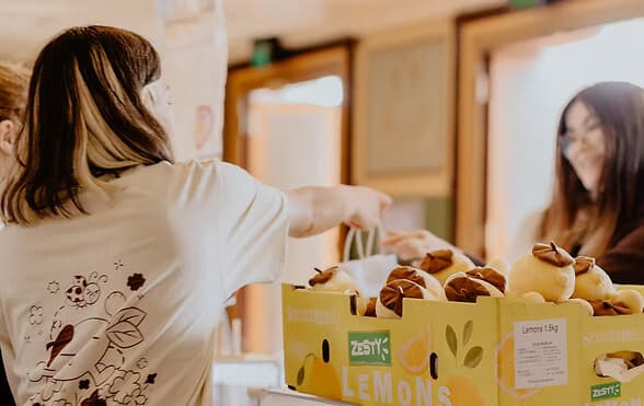 A stallholder in a Lucky Lemon t-shirt handing over a purchase